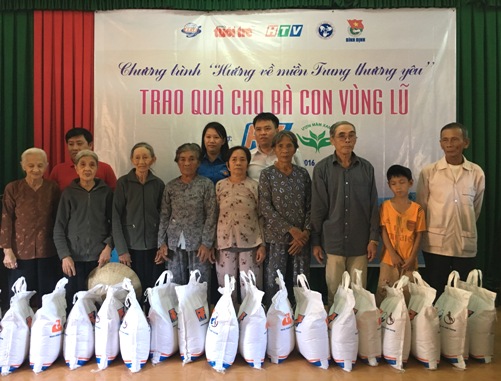 Đồng chí Huỳnh Thị Anh Thảo - Phó Bí thư Tỉnh đoàn, Chủ tịch Hội đồng Đội tỉnh cùng đại diện Báo Tuổi trẻ, công ty RICO FEED trao gạo hỗ trợ các gia đình thiệt hại do lũ